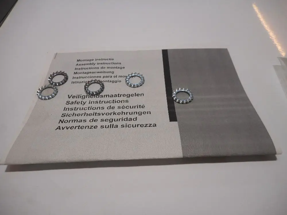 Mehrere Zahnscheiben aus Metall auf Anleitung mit Sicherheits- und Montageinformationen von Remeha, angezeigt auf einem hellen Untergrund.